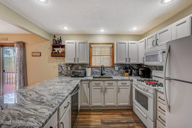 98 Roamingwood Rd, Lake Ariel, PA 18436 - kitchen featuring a peninsula, decorative backsplash, a sink, and white appliances