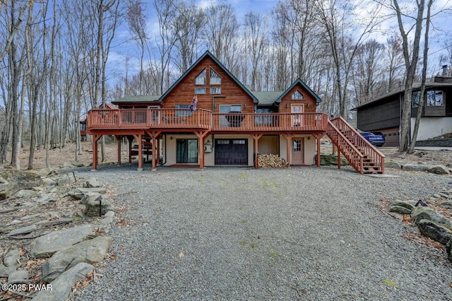 98 Roamingwood Rd, Lake Ariel, PA 18436 - back of house with stucco siding, gravel driveway, a deck, and stairs