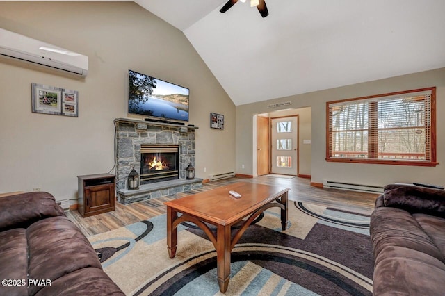 98 Roamingwood Rd, Lake Ariel, PA 18436 - living room with a wall mounted air conditioner, wood finished floors, a stone fireplace, a ceiling fan, and a baseboard heating unit