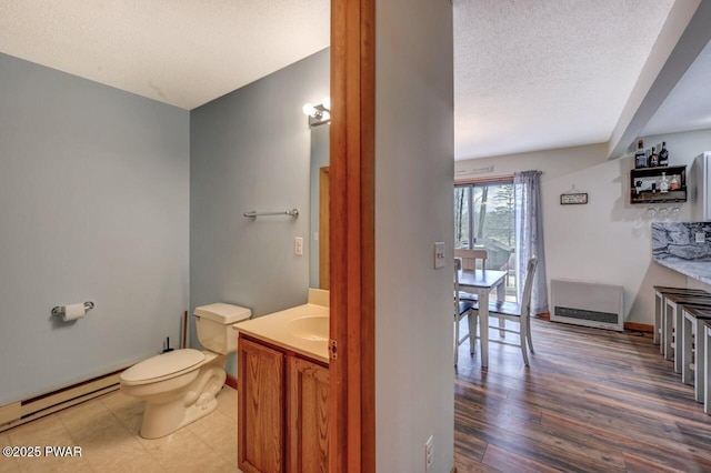 98 Roamingwood Rd, Lake Ariel, PA 18436 - half bathroom featuring wood finished floors, toilet, vanity, a baseboard heating unit, and a textured ceiling