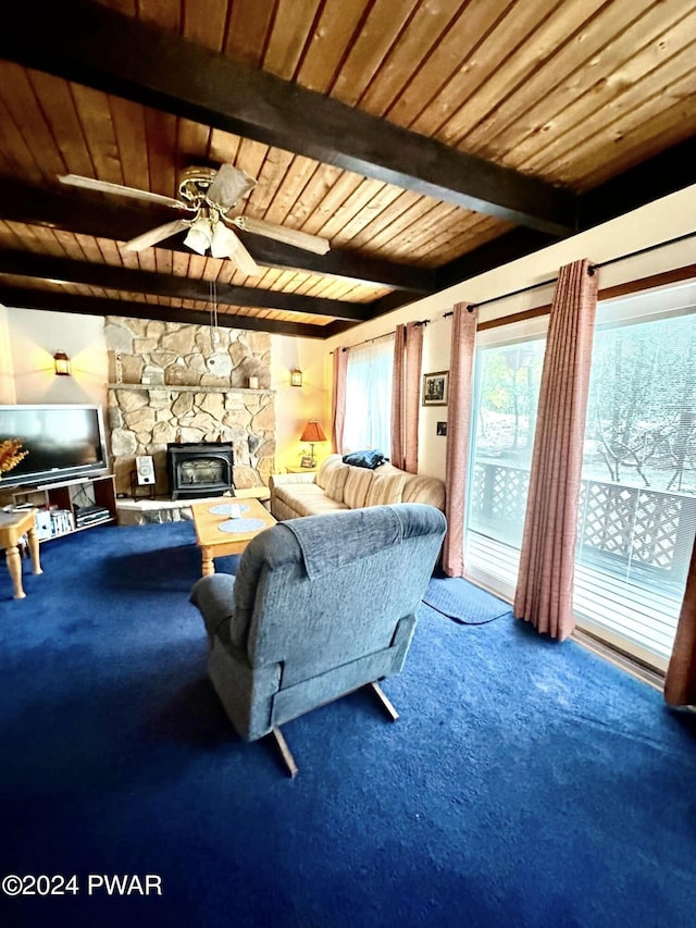 living room featuring carpet, a wood stove, ceiling fan, beamed ceiling, and wood ceiling