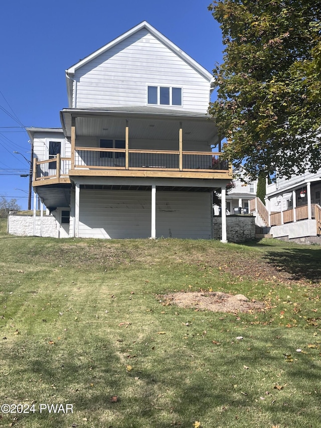 rear view of property featuring a lawn and a wooden deck