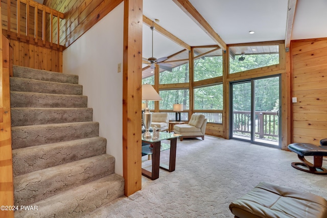 10 Cove Point Cir, Lakeville, PA 18438 - carpeted living room featuring wooden walls, beam ceiling, stairway, ceiling fan, and high vaulted ceiling