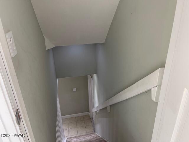 stairs with tile patterned floors and baseboards