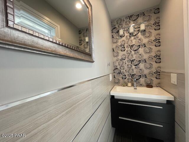 bathroom featuring vanity, tile walls, and a wainscoted wall