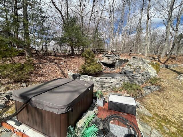 view of yard featuring fence and a hot tub