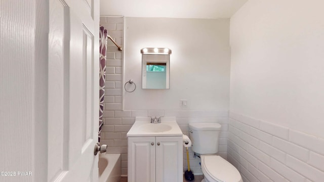 152 Fairview Dr, Dingmans Ferry, PA 18328 - bathroom featuring toilet, vanity, tile walls, shower / tub combo with curtain, and a wainscoted wall