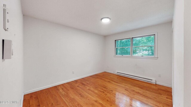 152 Fairview Dr, Dingmans Ferry, PA 18328 - empty room featuring a baseboard radiator, light wood finished floors, and baseboards