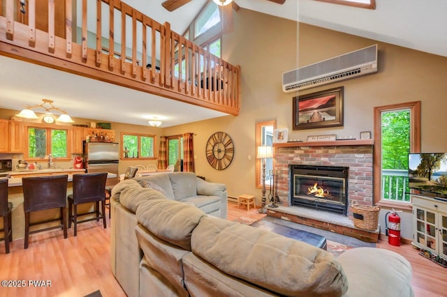 108 Minnow Ct, Lackawaxen, PA 18435 - living room with high vaulted ceiling, a wall unit AC, a ceiling fan, light wood finished floors, and a fireplace