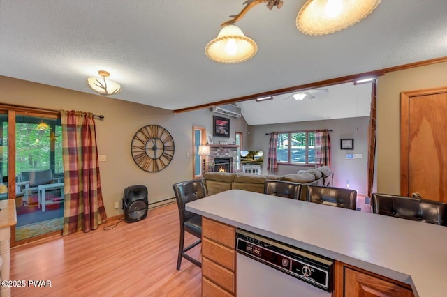108 Minnow Ct, Lackawaxen, PA 18435 - kitchen featuring dishwasher, light wood-style flooring, a wall unit AC, a fireplace, and light countertops