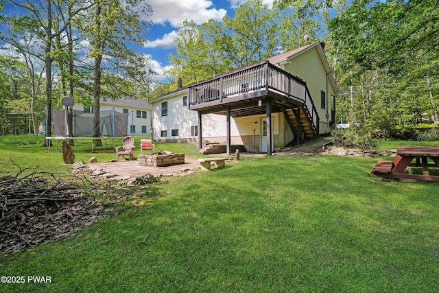 135 Kiel Rd, Milford, PA 18337 - back of house with a trampoline, a wooden deck, an outdoor fire pit, stairs, and a yard