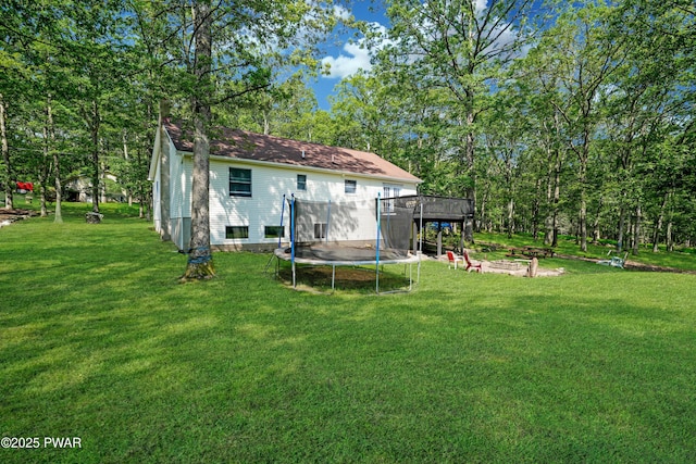 135 Kiel Rd, Milford, PA 18337 - back of house with a trampoline, a yard, a deck, and a fire pit