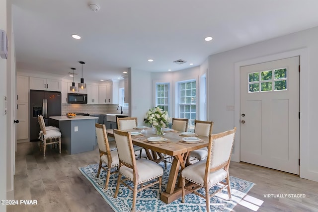 dining area with sink and light hardwood / wood-style flooring