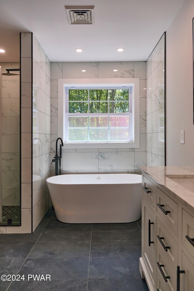 bathroom featuring tile walls, vanity, and shower with separate bathtub