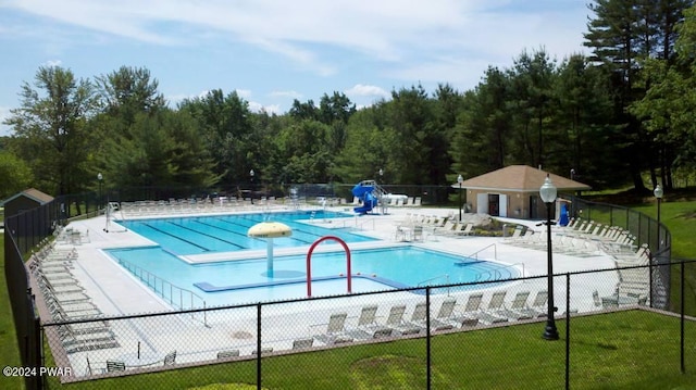 view of pool with a patio and a lawn