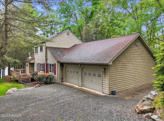 141 Arrowhead Cir, Newfoundland, PA 18445 - view of front of house featuring roof with shingles, a deck, a garage, and gravel driveway