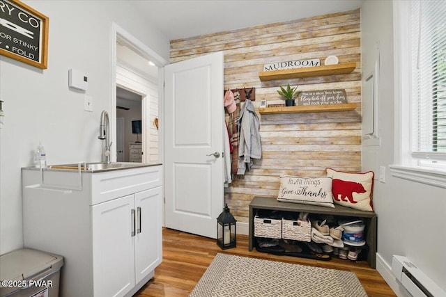 141 Arrowhead Cir, Newfoundland, PA 18445 - mudroom featuring a baseboard heating unit, wood walls, a sink, light wood finished floors, and baseboards