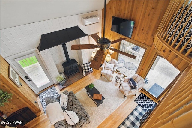 141 Arrowhead Cir, Newfoundland, PA 18445 - living room featuring a wood stove, wood finished floors, wood walls, and ceiling fan