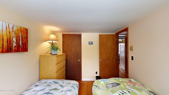 bedroom featuring baseboards and wood finished floors