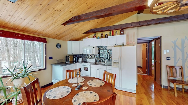 kitchen featuring white appliances, tasteful backsplash, white cabinets, dark countertops, and vaulted ceiling with beams