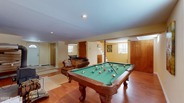 rec room with baseboards, light wood finished floors, a wood stove, and recessed lighting