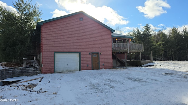 snow covered property featuring a garage