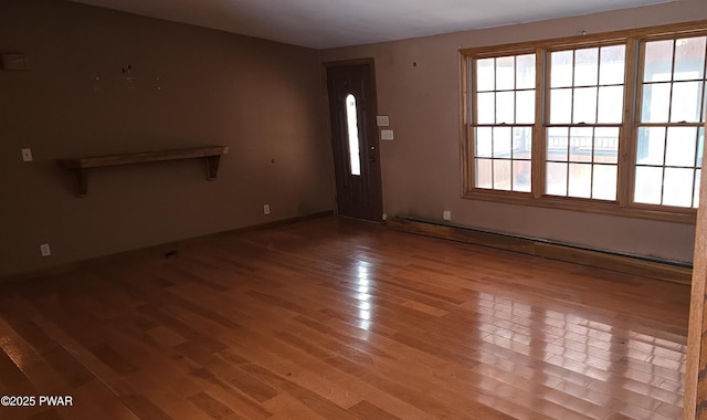 interior space with a baseboard radiator and light hardwood / wood-style flooring