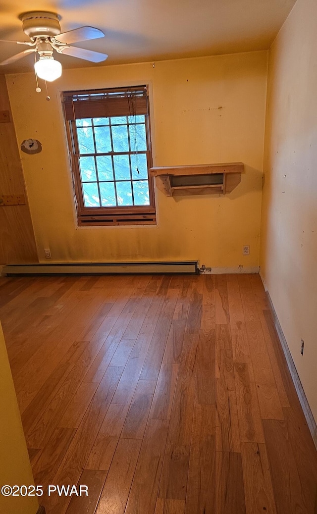 unfurnished room featuring ceiling fan, baseboard heating, and hardwood / wood-style floors