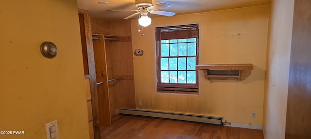 interior space with light wood-type flooring, baseboard heating, and ceiling fan