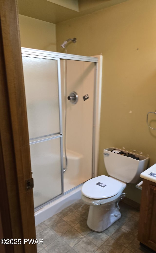 bathroom featuring toilet, walk in shower, and vanity