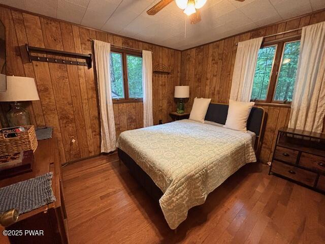 30 Bear Hill Rd, Lake Ariel, PA 18436 - bedroom featuring wooden walls, wood finished floors, and ceiling fan