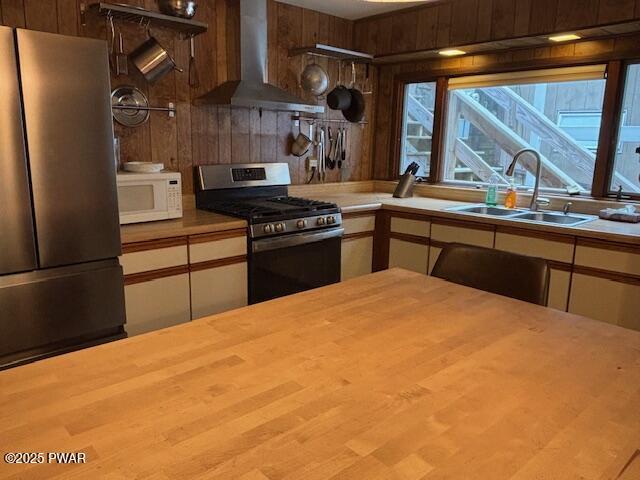 30 Bear Hill Rd, Lake Ariel, PA 18436 - kitchen featuring wall chimney range hood, stainless steel appliances, and wood walls