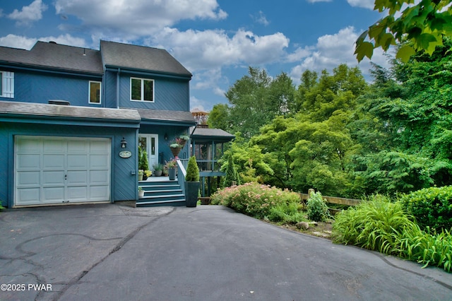 149 Bennett Ave Unit J, Milford, PA 18337 - view of front of house featuring a garage, asphalt driveway, and a sunroom
