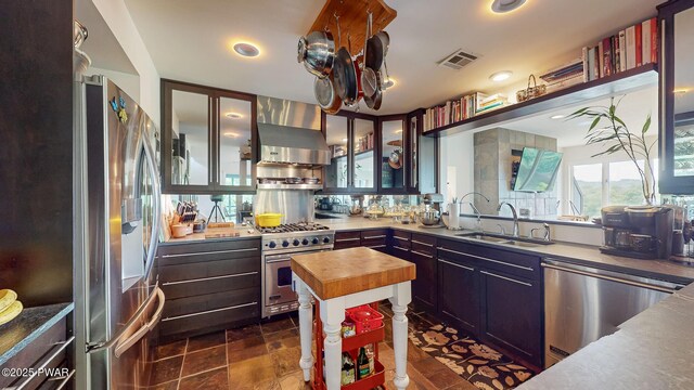 149 Bennett Ave Unit J, Milford, PA 18337 - kitchen with appliances with stainless steel finishes, wood counters, wall chimney exhaust hood, glass insert cabinets, and dark stone finish floors