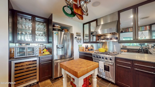 149 Bennett Ave Unit J, Milford, PA 18337 - kitchen with beverage cooler, appliances with stainless steel finishes, wall chimney exhaust hood, wood counters, and glass insert cabinets