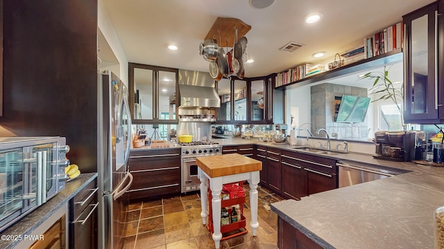 149 Bennett Ave Unit J, Milford, PA 18337 - kitchen with stainless steel appliances, butcher block countertops, wall chimney range hood, glass insert cabinets, and recessed lighting