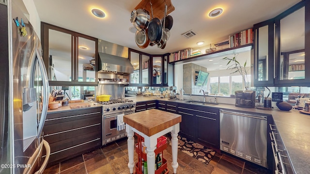 149 Bennett Ave Unit J, Milford, PA 18337 - kitchen with stainless steel appliances, wall chimney range hood, wood counters, glass insert cabinets, and recessed lighting