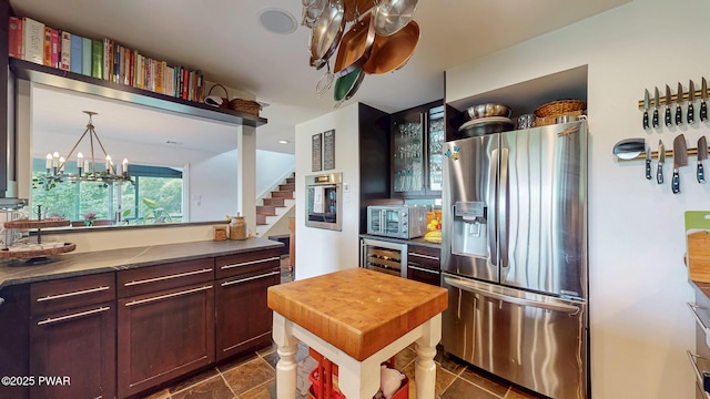 149 Bennett Ave Unit J, Milford, PA 18337 - kitchen with stainless steel appliances, beverage cooler, a chandelier, wooden counters, and glass insert cabinets