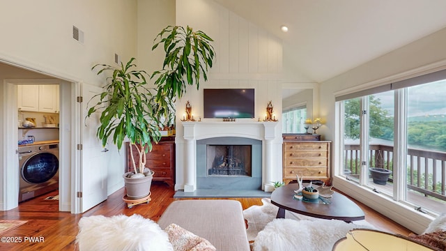 149 Bennett Ave Unit J, Milford, PA 18337 - living room featuring washer / dryer, high vaulted ceiling, wood finished floors, and a fireplace