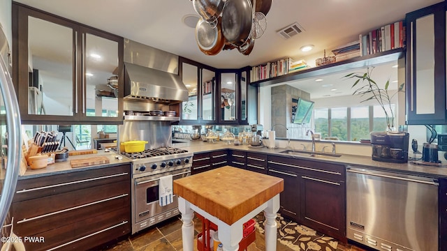 149 Bennett Ave Unit J, Milford, PA 18337 - kitchen with appliances with stainless steel finishes, wooden counters, wall chimney range hood, and glass insert cabinets