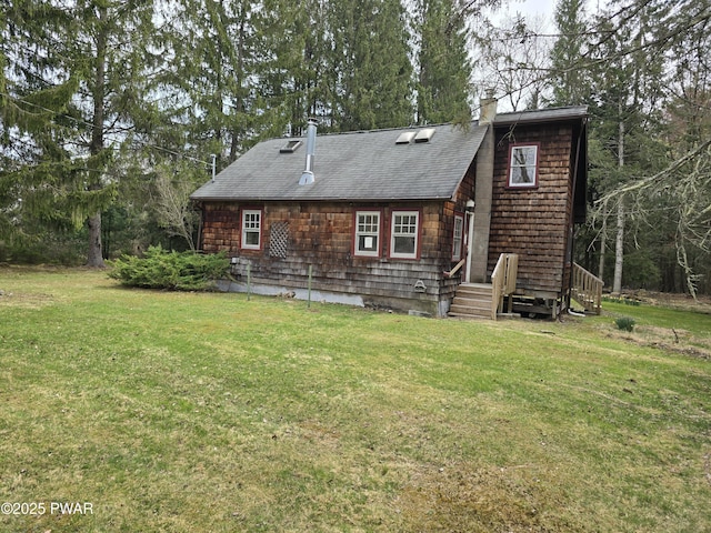 back of property featuring a yard, a chimney, and roof with shingles