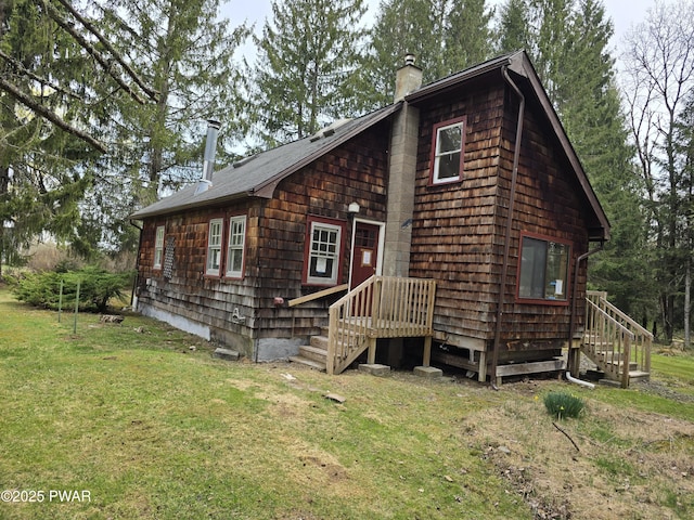 view of front of property with a shingled roof, a chimney, and a front yard