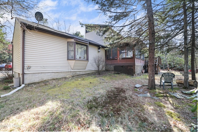 back of property featuring a wooden deck and a sunroom