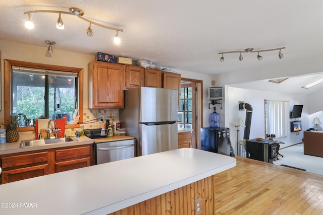 kitchen with a wealth of natural light, sink, appliances with stainless steel finishes, and tasteful backsplash