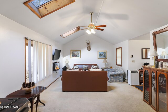 carpeted living room featuring ceiling fan, a healthy amount of sunlight, and vaulted ceiling with skylight