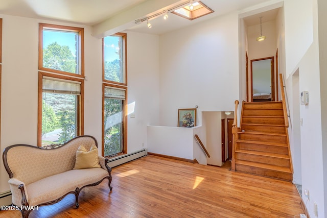20 Clemen V Muller St, Beach Lake, PA 18405 - living area featuring a baseboard radiator, healthy amount of natural light, light wood-style floors, track lighting, and a high ceiling