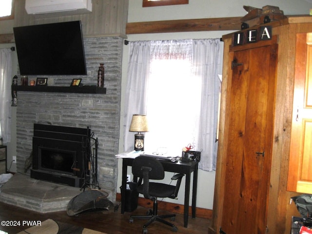 living room featuring a wall mounted air conditioner and a fireplace