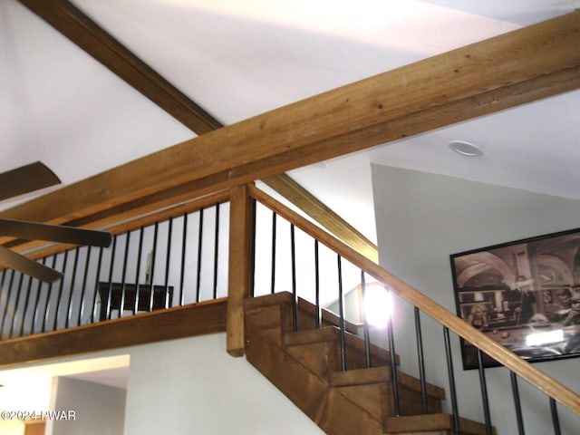 stairway with lofted ceiling with beams