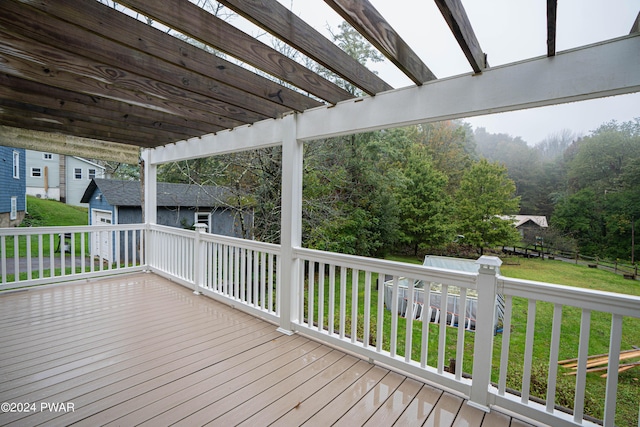 wooden terrace featuring a lawn and a pergola