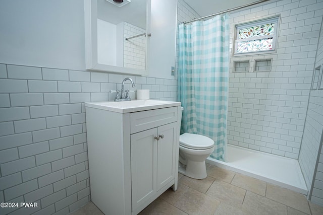 bathroom with vanity, backsplash, toilet, tile walls, and walk in shower